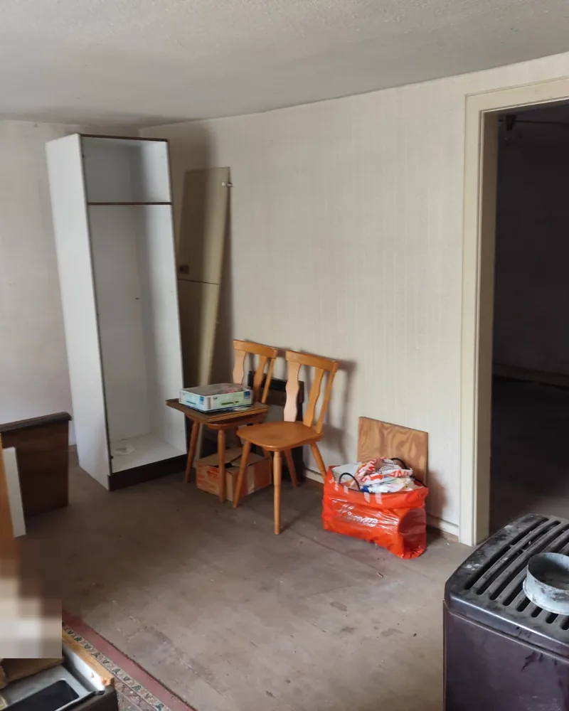 Messie-Wohnung Rastatt — Referenz: Zimmer mit Ofen, Möbeln und Kartons vor der Räumung